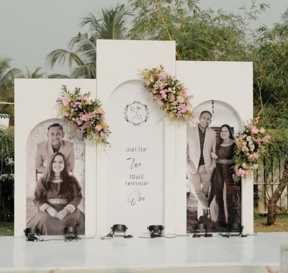 Three white arched panels with couple portraits, a monogram and pastel flowers